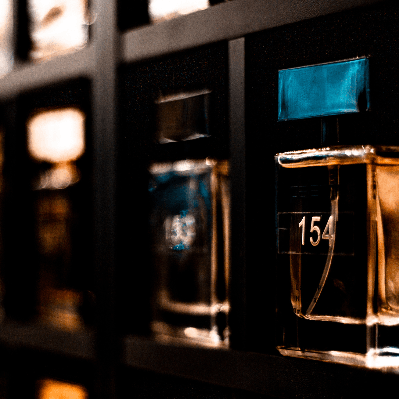 Auswahl verschiedener Aromalux Parfümflakons auf einem Regal, zeigt die Produktvielfalt